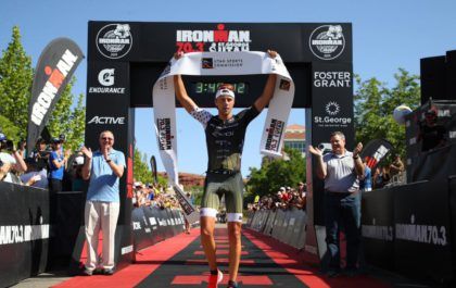 Belgisch-Amerikaanse triatleet Rudy Von Berg steekt het finishlint omhoog na zijn zege in de 70.3 Ironman van St-George