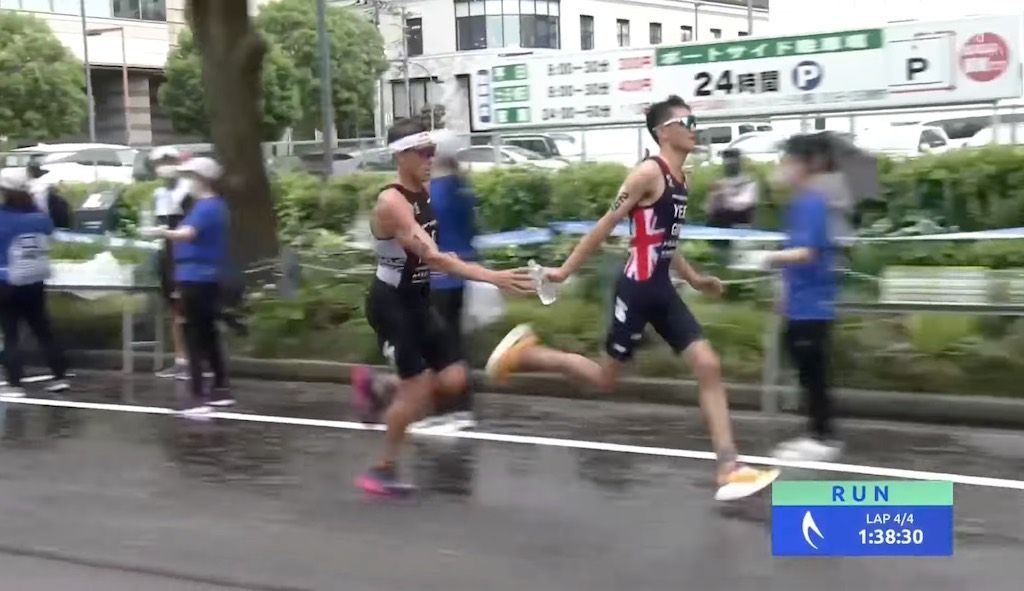 Hét triatlonmoment van 2022: Alex Yee geeft waterflesje door aan Hayden Wilde en krijgt schouderklopje