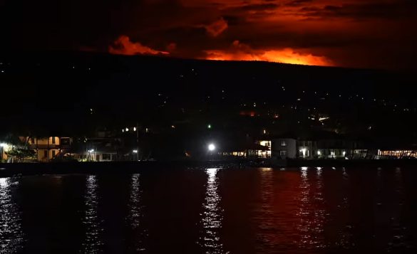 Screenshot van de rode gloed van de top van Mauna Loa gezien vanaf de pier in Kailua-Kona waar jaarlijks de Ironman plaatsvindt (foto: 3athlon.be)